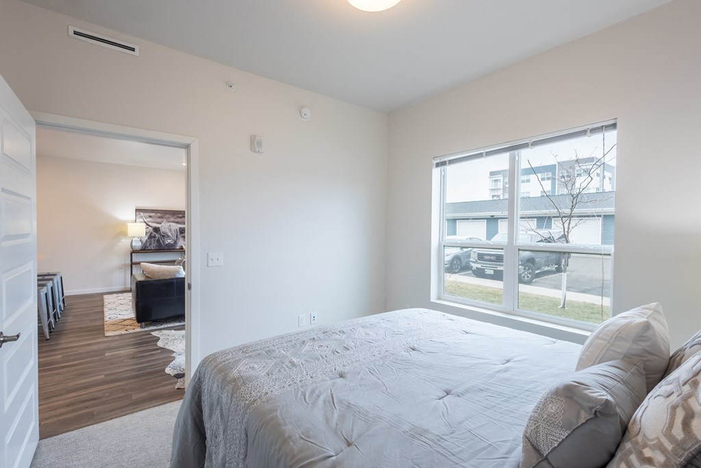 a bedroom with a large bed and a large window at Technology Park Apartments, Minnesota