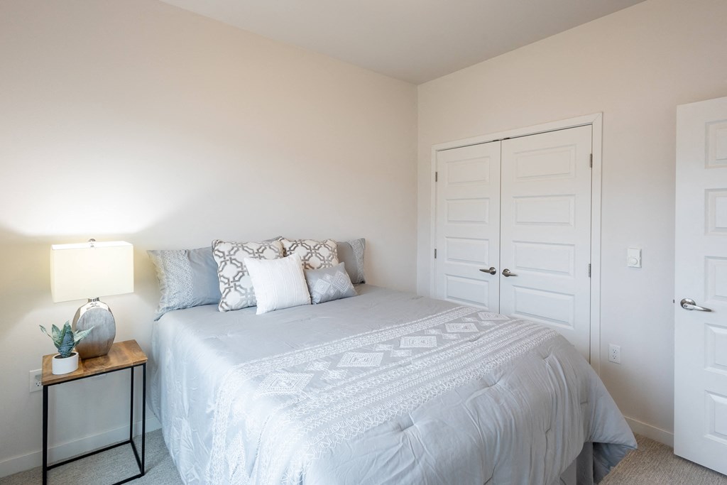 a white bedroom with a white bed and a white closet at Technology Park Apartments, Rochester, 55901