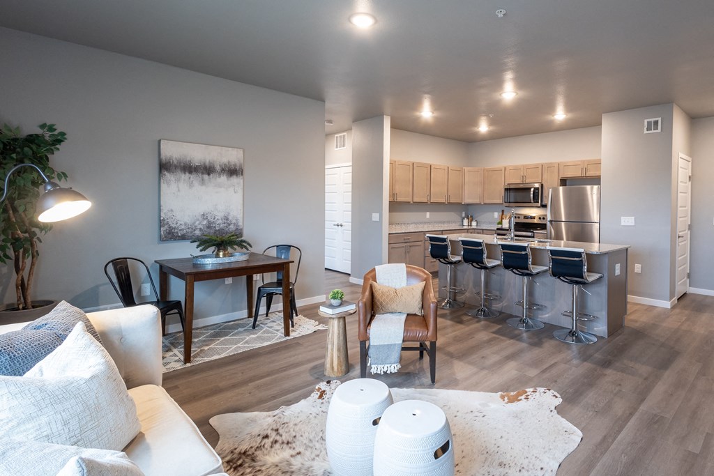 an open living room and kitchen with a dining room table and chairs at Technology Park Apartments, Rochester