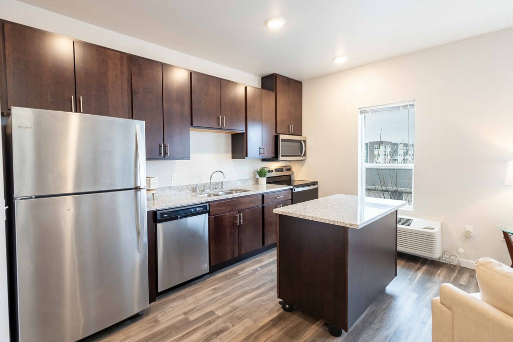 a kitchen with stainless steel appliances and wooden cabinets at Technology Park Apartments, Rochester, MN