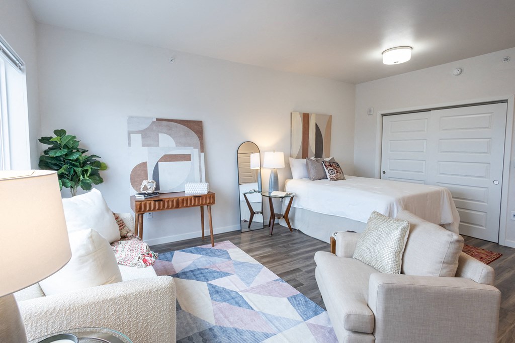 a bedroom with a bed and a living room with a couch and a chair at Technology Park Apartments, Minnesota, 55901