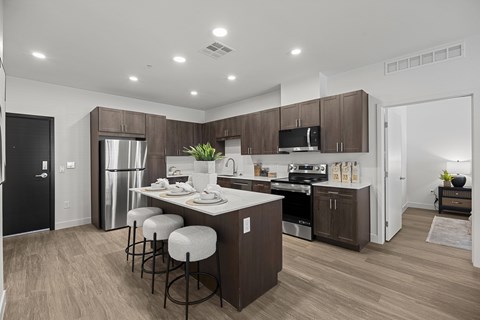 A modern kitchen with dark brown cabinets and a white island.
