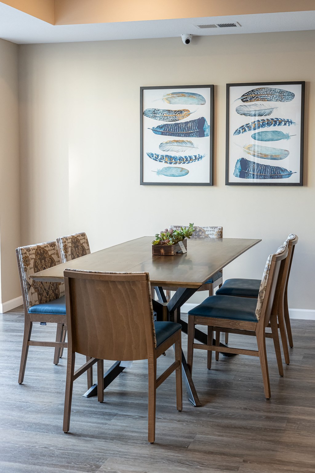 a dining room with a wooden table and chairs and two fish artwork on the wall