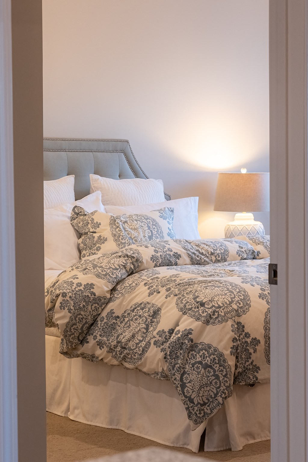 a bedroom with a bed with blue and white comforter and pillows