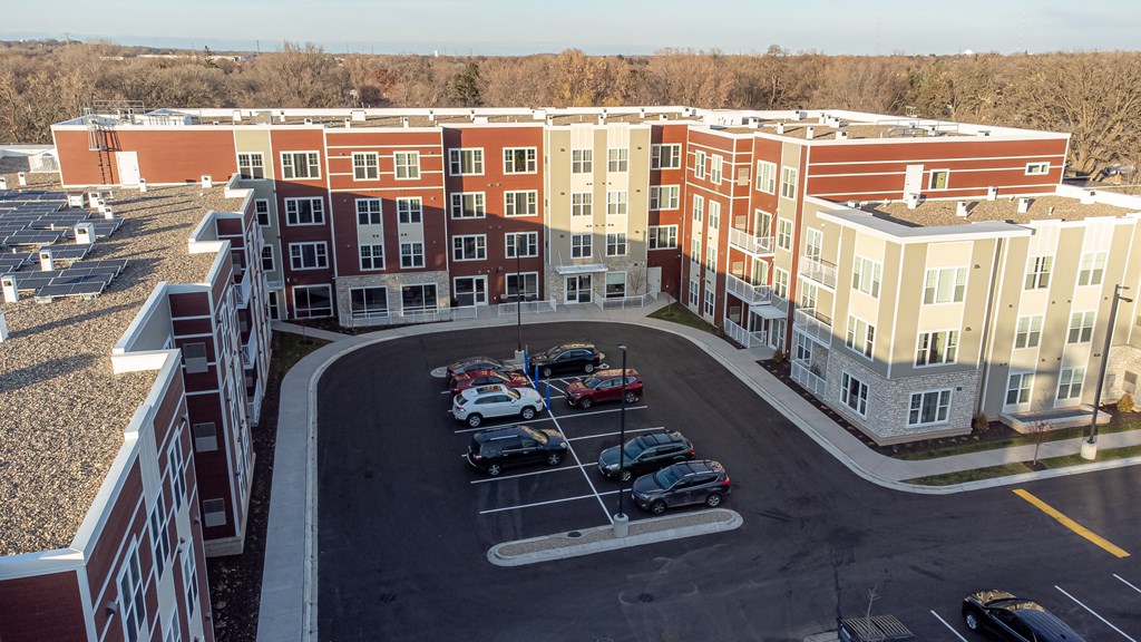 an aerial view of a parking lot in front of an apartment building