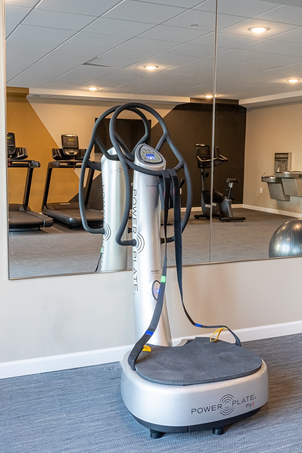 an exercise machine in a gym in front of a mirror