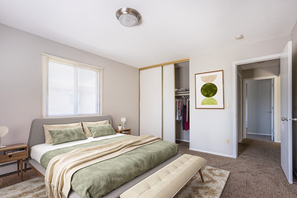 a bedroom with a bed and a closet at Villa Del Coronado Apartments, Brooklyn Park, MN