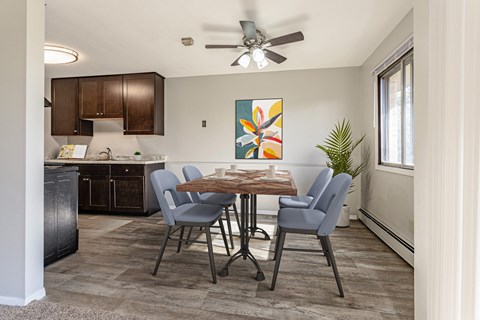 an open kitchen and dining room with a table and chairs and a ceiling fan