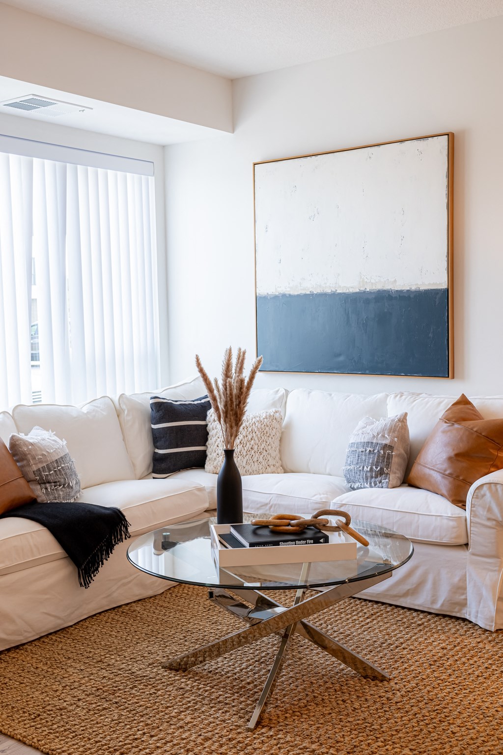 a living room with a white couch and a glass coffee table