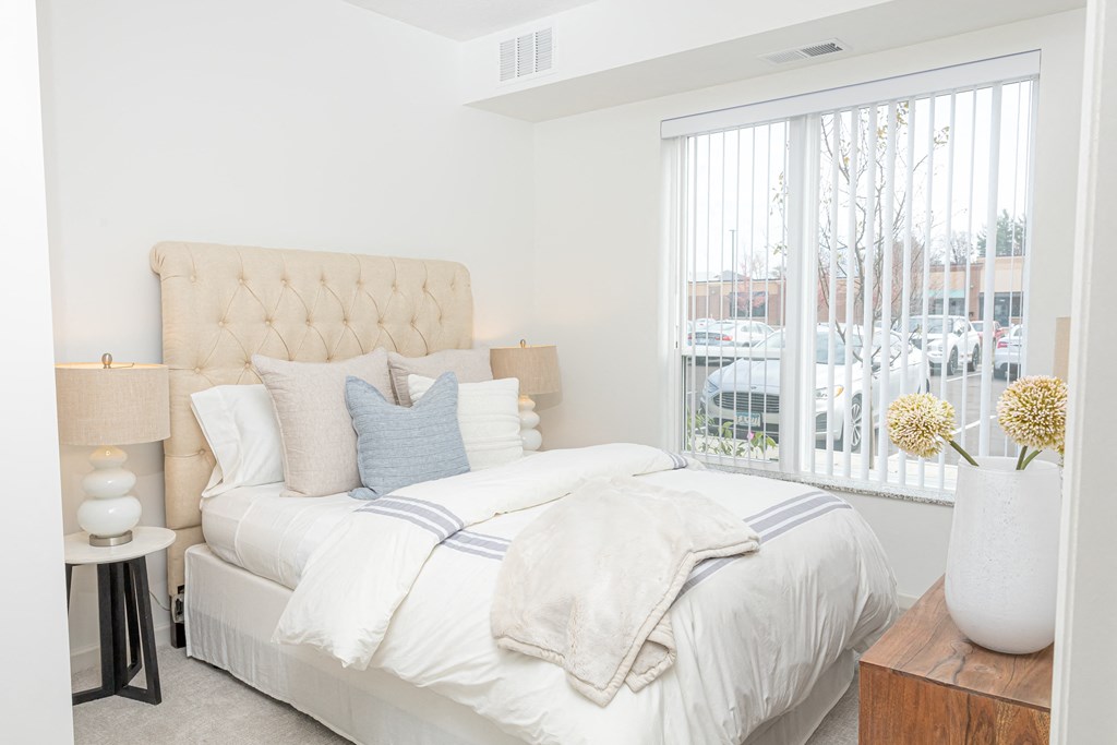 a bedroom with a large bed and a large window