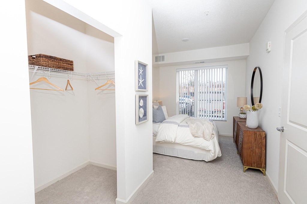 a bedroom with a bed and a closet and a window