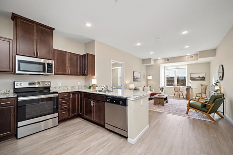 A kitchen with brown cabinets and stainless steel appliances at The Winslow 62+ Apartments, Minnesota, 55118