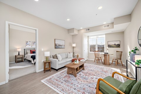 A living room with a white couch, a coffee table, and a rug at The Winslow 62+ Apartments, West St Paul, MN