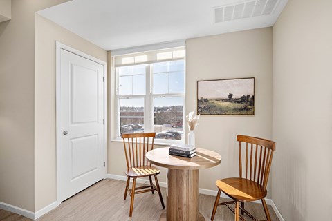 A room with a table and chairs and a painting on the wall at The Winslow 62+ Apartments, West St Paul, MN, 55118