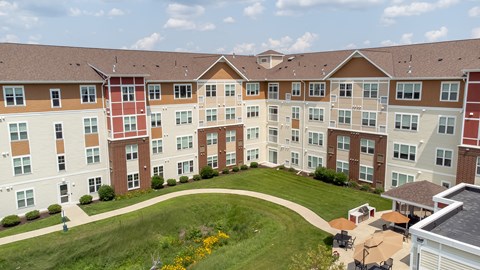 an aerial view of an apartment building on a green lawn at The Winslow 62+ Apartments, West St Paul
