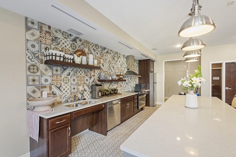 a kitchen with tiles on the wall and a white counter top at The Winslow 62+ Apartments, West St Paul, Minnesota