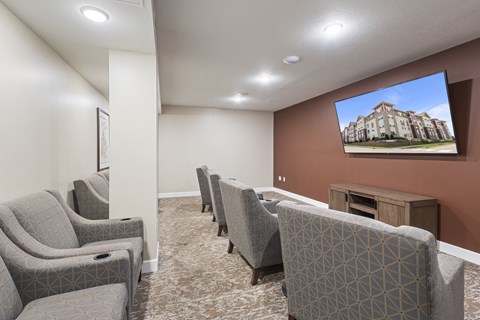 a community room with couches and chairs and a tv on the wall at The Winslow 62+ Apartments, Minnesota