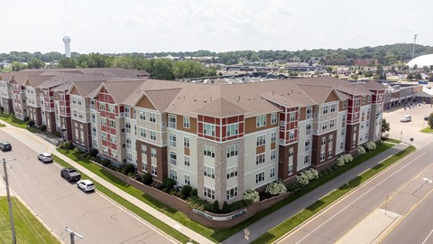 an aerial view of an apartment building on a city street at The Winslow 62+ Apartments, Minnesota, 55118