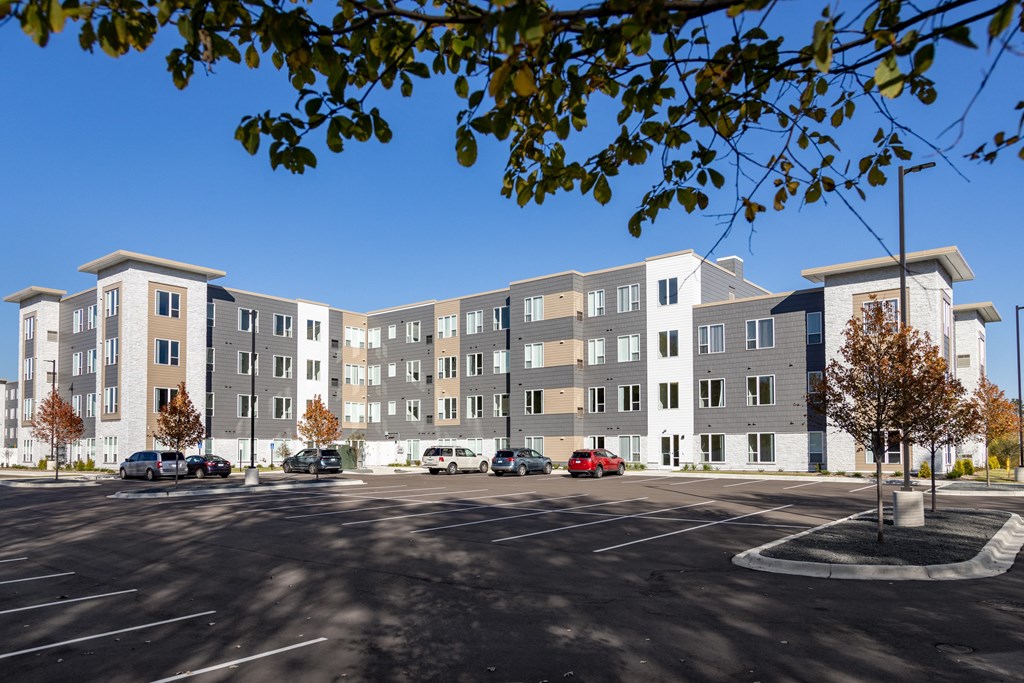 a large apartment building with cars parked in a parking lot