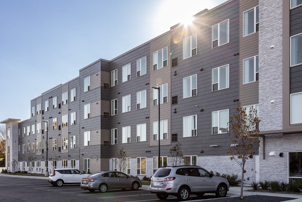 a large apartment building with cars parked in front of it