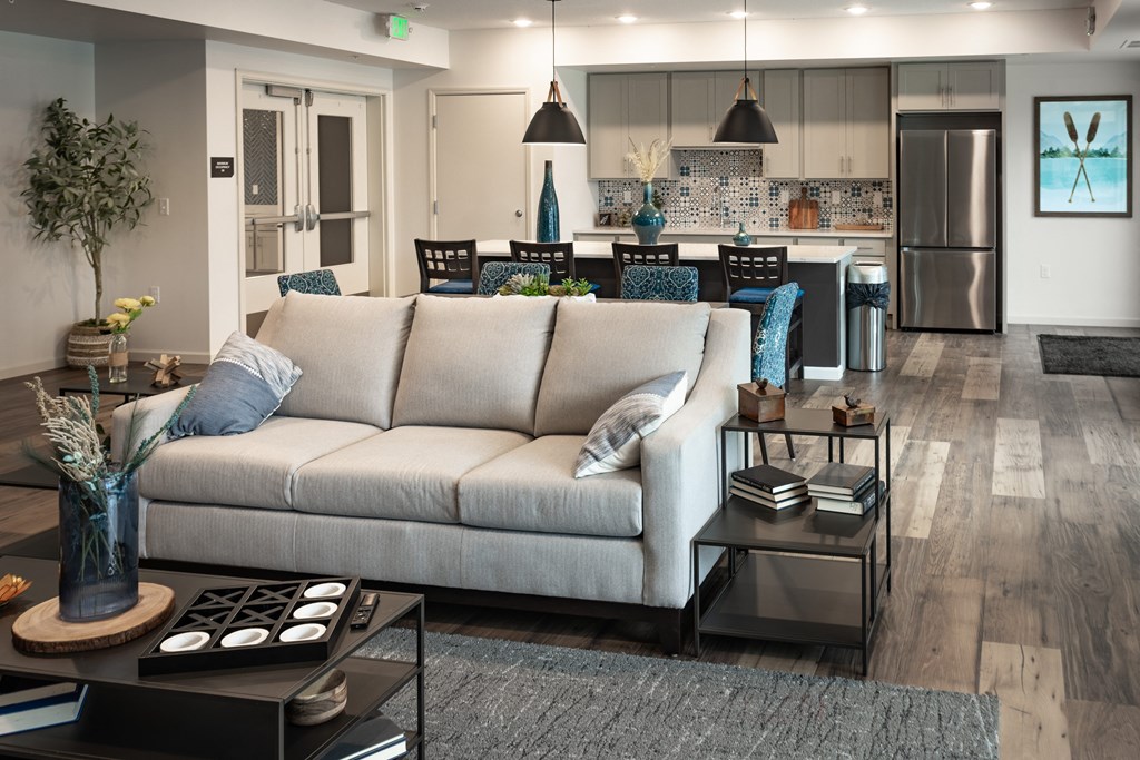 a living room with a couch in front of a kitchen