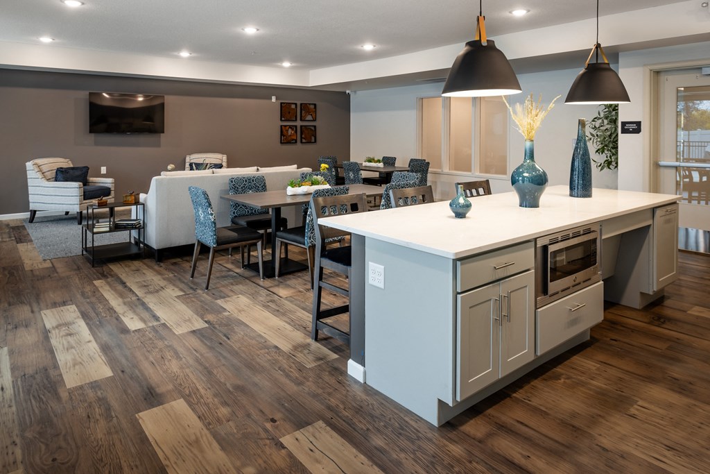 a kitchen with a large island and a dining room with a table and chairs