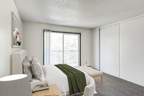 a bedroom with a bed and a chair and a window