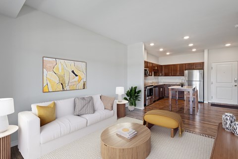 A modern living room with a white couch and a yellow accent pillow.