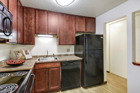 a kitchen with black appliances and wooden cabinets