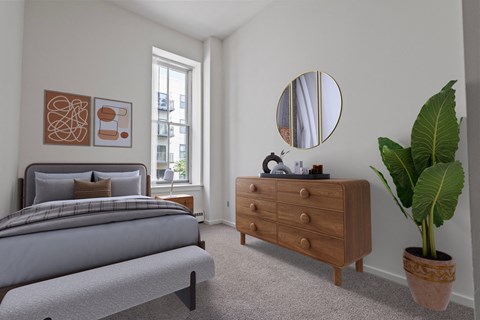 A bedroom with a bed, dresser, and mirror. at Parkside Apartments, St. Paul
