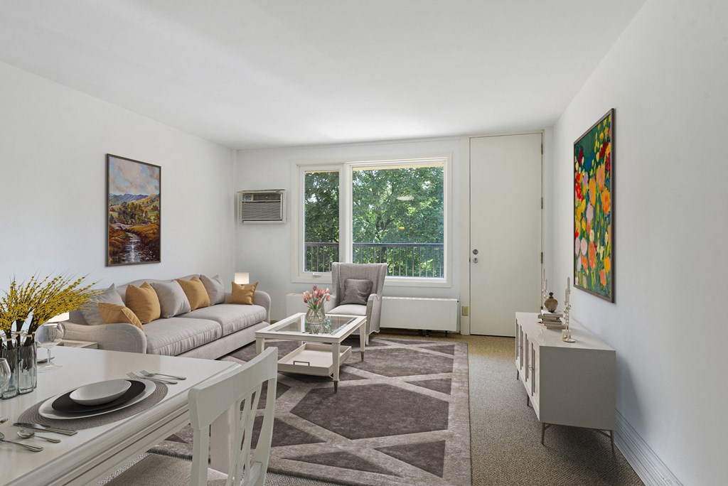 a living room with a couch and a table and a window at Humboldt Senior 55+ Apartments, Saint Paul