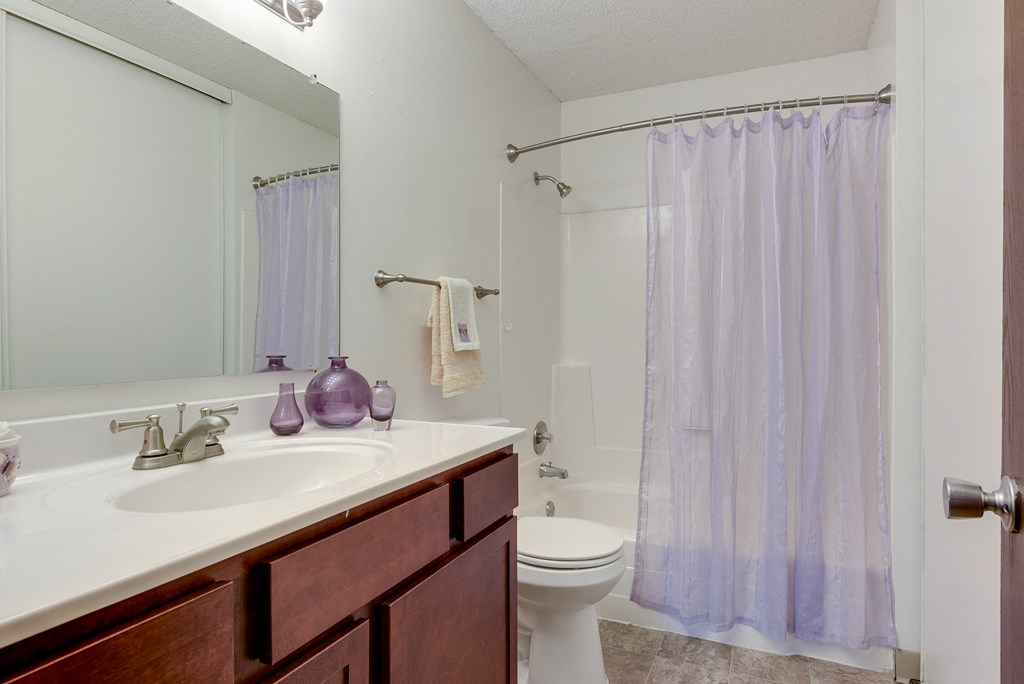 a bathroom with a white toilet and white countertops