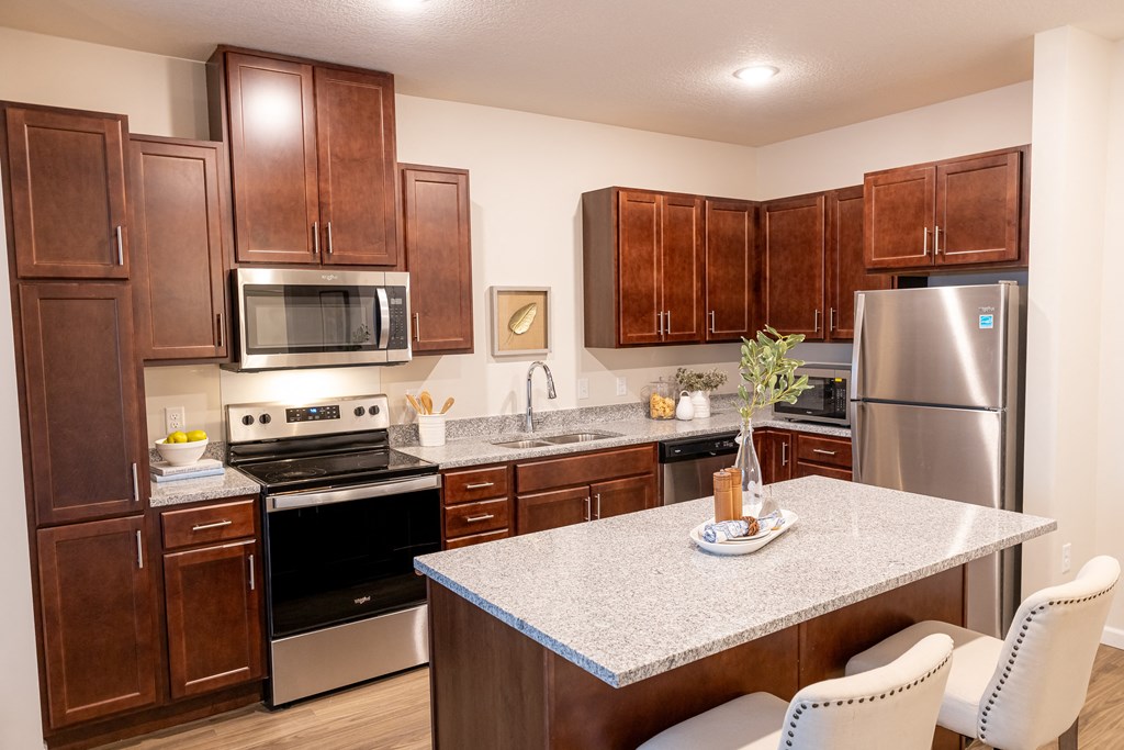 full kitchen with granite countertops and stainless steel appliances at the reserve at south coast