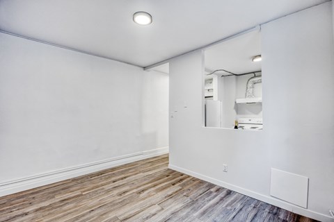 A room with a white wall and a wooden floor.