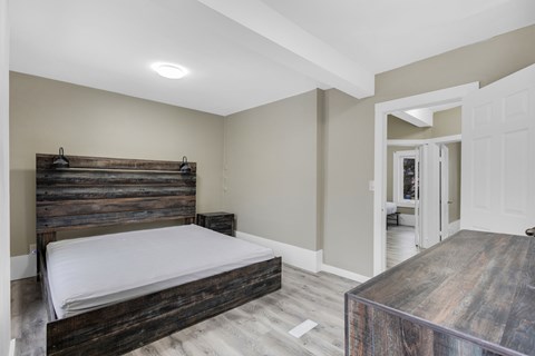 A bedroom with a bed and a wooden coffee table.