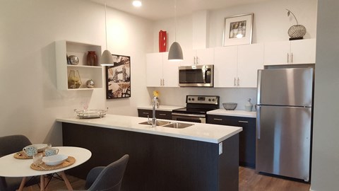 A modern kitchen with a stainless steel refrigerator and a white countertop.