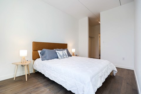 a bedroom with white walls and a bed with blue pillows