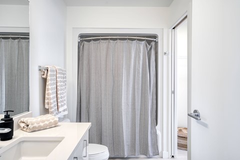 A bathroom with a white sink and a shower curtain.