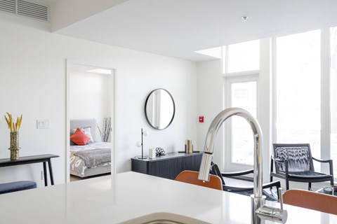 A modern kitchen with a white countertop and a large sink.