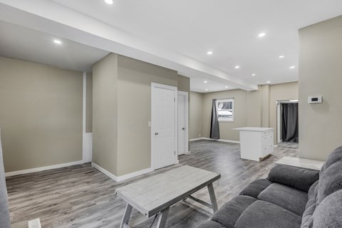 A living room with a grey couch and a wooden table.