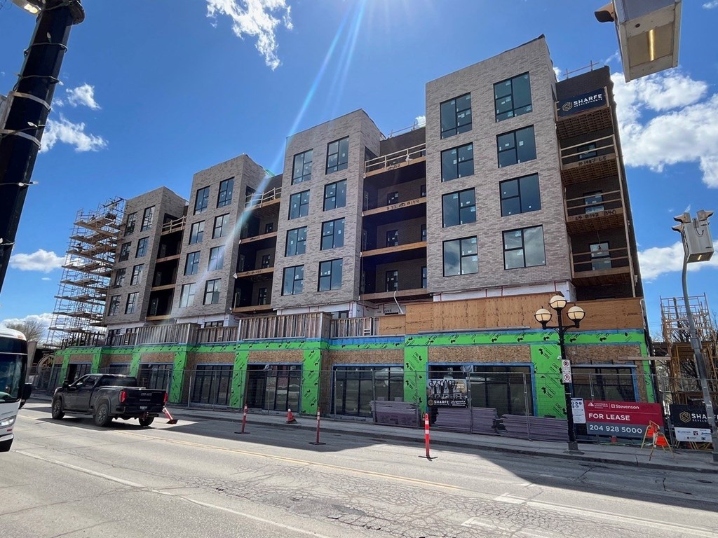 a building with green paint on it on the side of a street