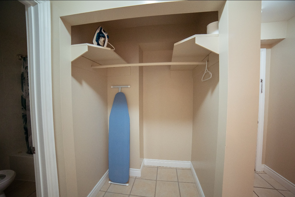 A blue surfboard is leaning against the wall in a small room.