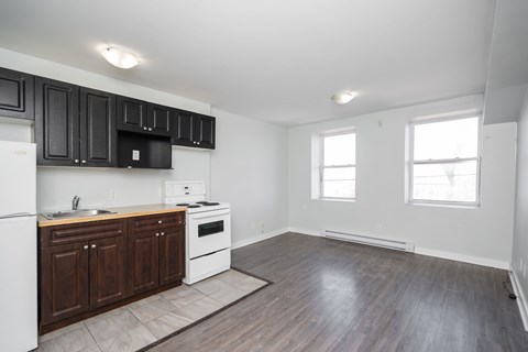 A kitchen with dark wood cabinets and white appliances.