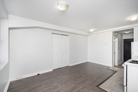 A room with a white door and a brown rug on the floor.