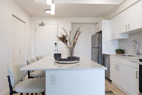 A white kitchen with a table and chairs.