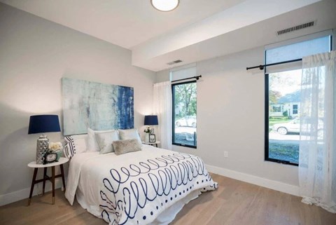 A bedroom with a large bed and a painting on the wall.