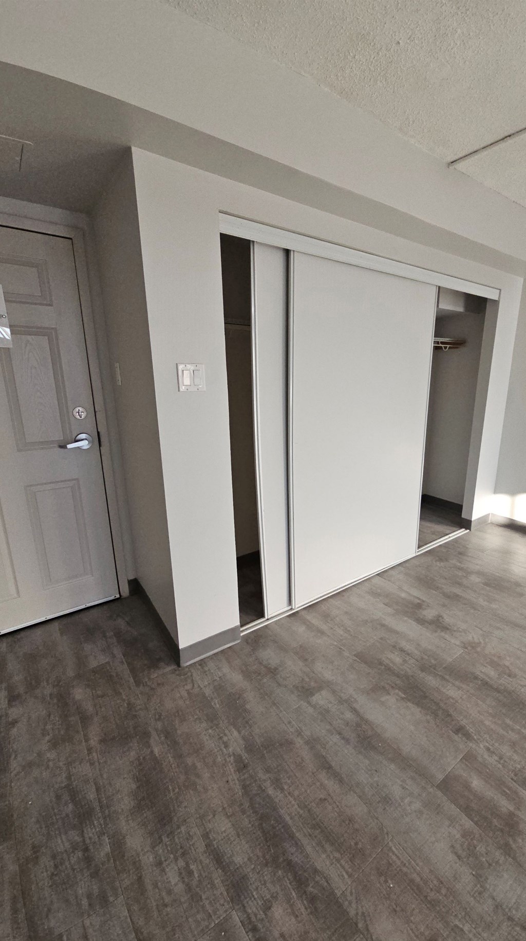 A white door is open in a room with grey carpet.