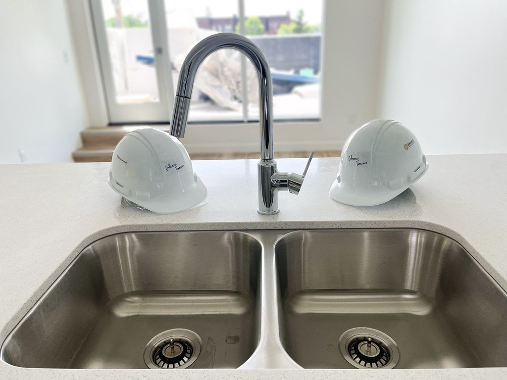 a kitchen sink with two construction hats on it