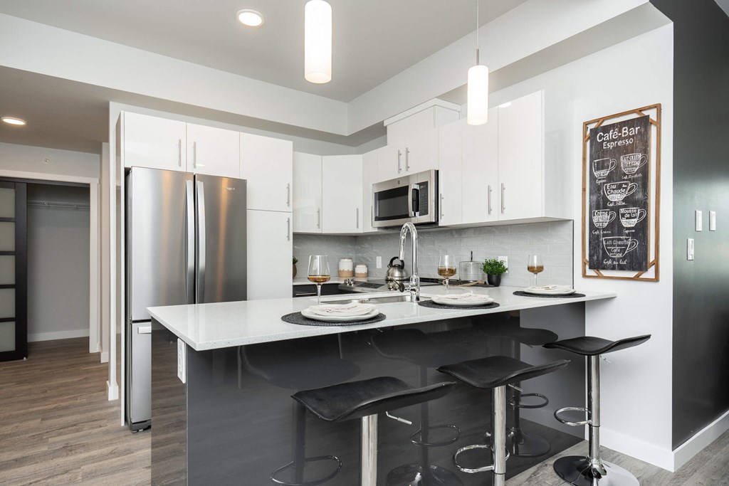 a kitchen with an island and a stainless steel refrigerator