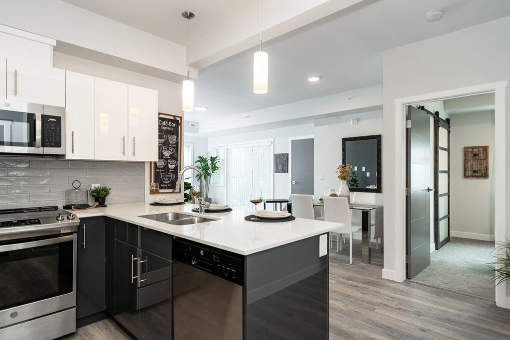 an open kitchen and living room with a large white counter top